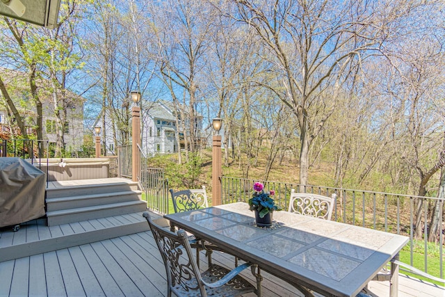deck with outdoor dining area, grilling area, and a covered hot tub