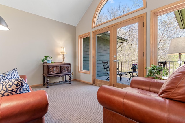living area featuring carpet, plenty of natural light, vaulted ceiling, and french doors