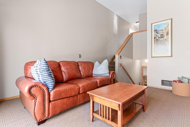 living area featuring light colored carpet, visible vents, and baseboards