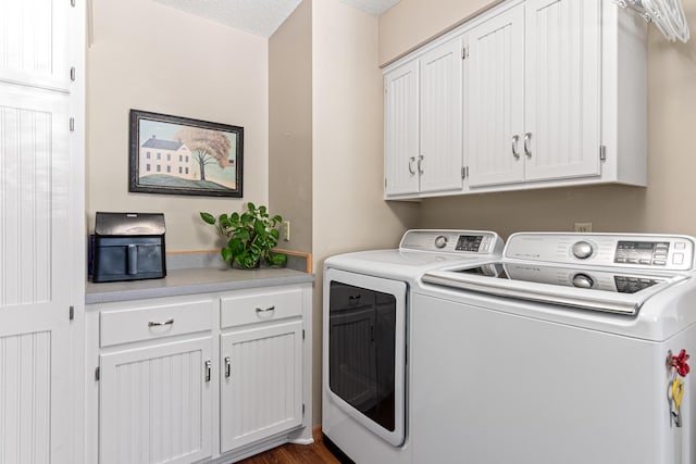clothes washing area featuring washing machine and dryer and cabinet space