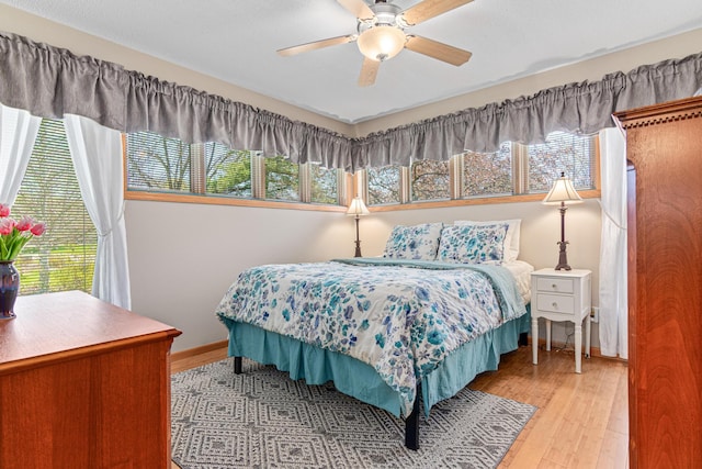 bedroom with hardwood / wood-style flooring, baseboards, and a ceiling fan