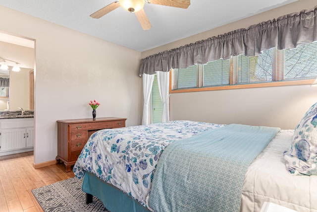 bedroom with ensuite bath, light wood-type flooring, and ceiling fan