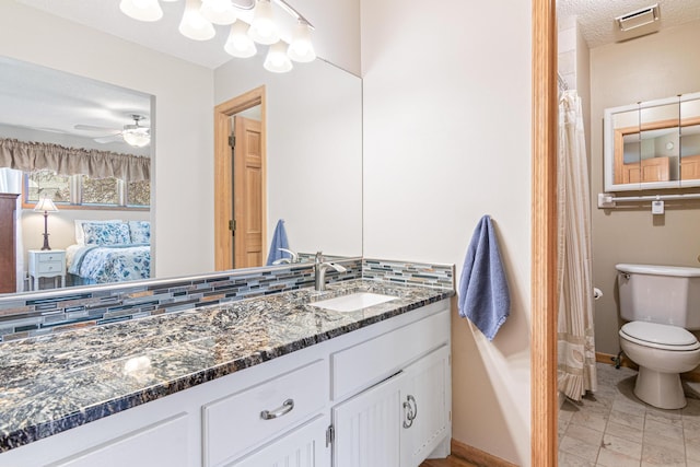 ensuite bathroom with toilet, baseboards, ensuite bathroom, ceiling fan, and vanity