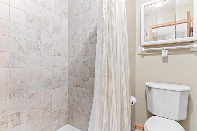 full bathroom featuring toilet and tiled shower