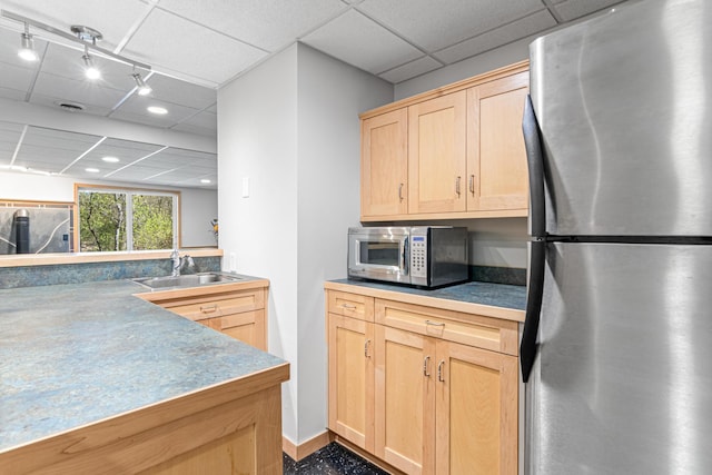 kitchen featuring a sink, stainless steel appliances, recessed lighting, light brown cabinetry, and a drop ceiling