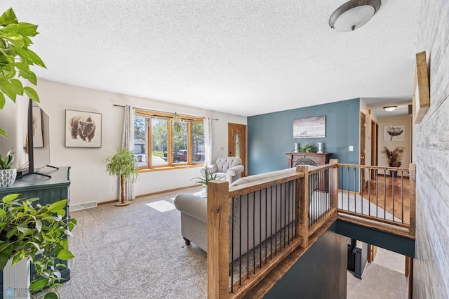 carpeted living room with a textured ceiling and baseboards
