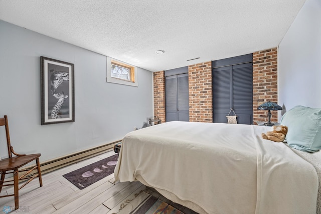 bedroom with wood finished floors, a textured ceiling, and baseboard heating
