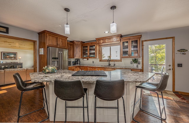 4224 Thunder Lake Lodge Dr NE, Remer, MN 56672 - kitchen featuring stainless steel fridge, brown cabinetry, glass insert cabinets, decorative backsplash, and dark wood finished floors