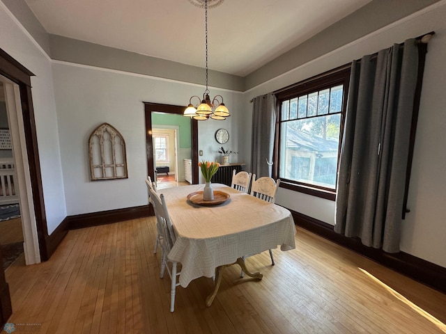 911 8th St N, Fargo, ND 58102 - dining area featuring baseboards, hardwood / wood-style floors, and a chandelier