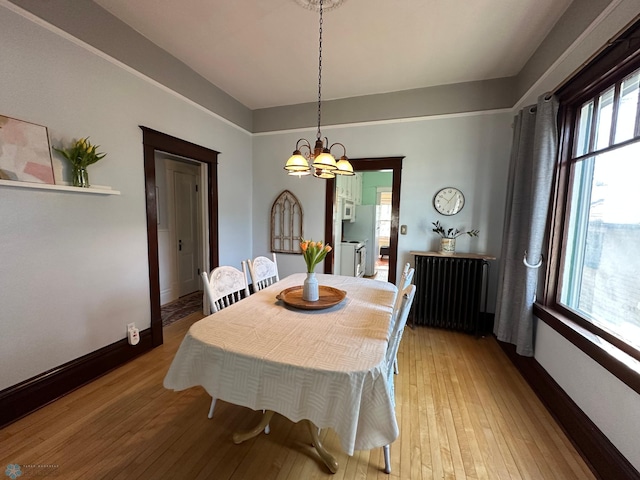 911 8th St N, Fargo, ND 58102 - dining space with a notable chandelier, light wood-style flooring, baseboards, and radiator heating unit