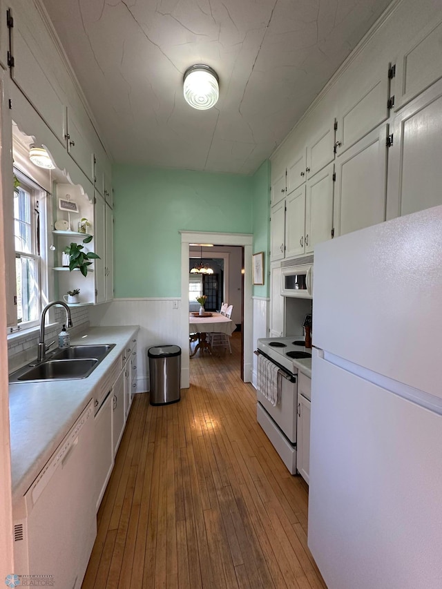 911 8th St N, Fargo, ND 58102 - kitchen featuring a sink, hardwood / wood-style floors, white cabinets, white appliances, and light countertops
