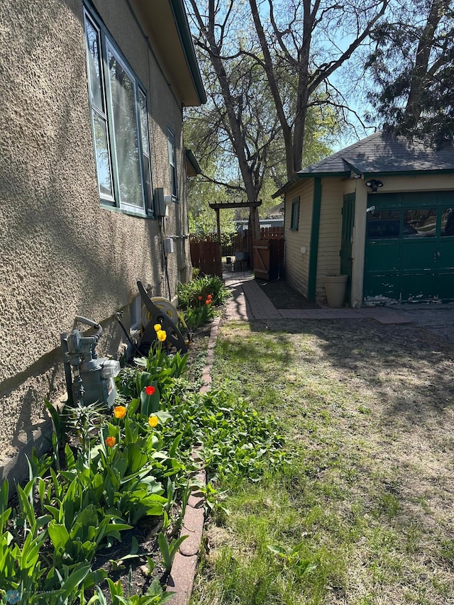 911 8th St N, Fargo, ND 58102 - view of home's exterior with stucco siding and fence