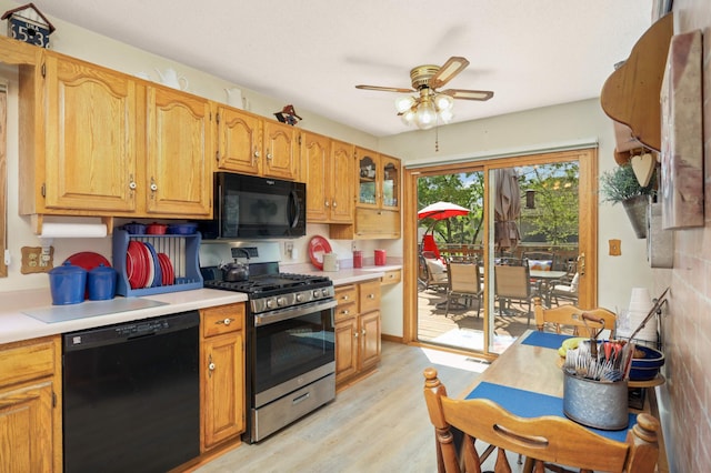 11438 Zea St NW, Coon Rapids, MN 55433 - kitchen with black appliances, ceiling fan, light wood-style floors, light countertops, and glass insert cabinets