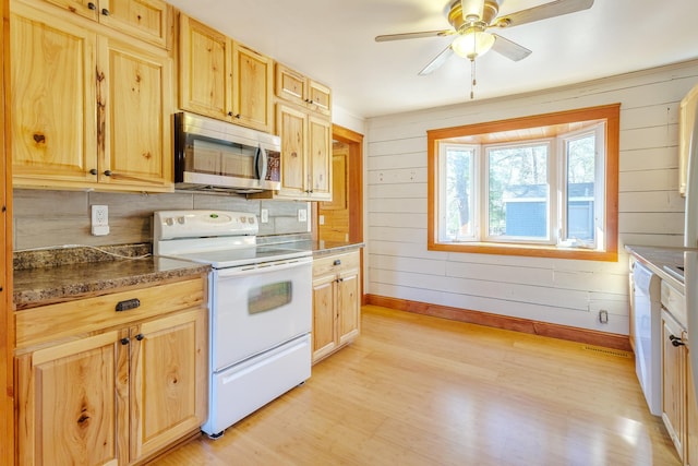 kitchen with stainless steel microwave, baseboards, light wood-style floors, and electric range