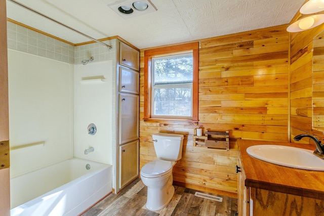 full bathroom with shower / bath combination, toilet, visible vents, wood walls, and wood finished floors