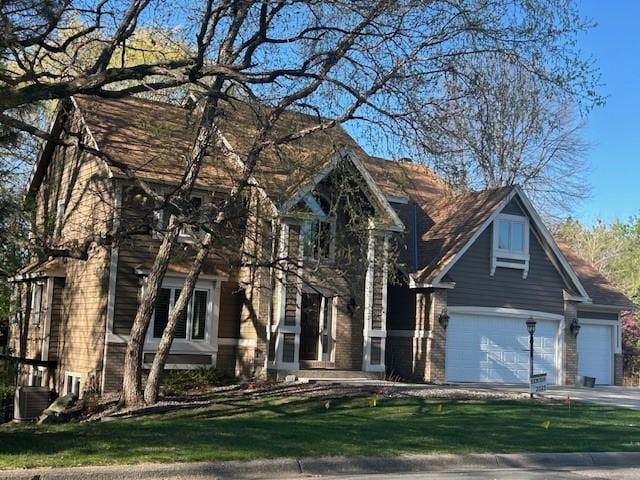 view of front of home with concrete driveway, a front yard, and a garage