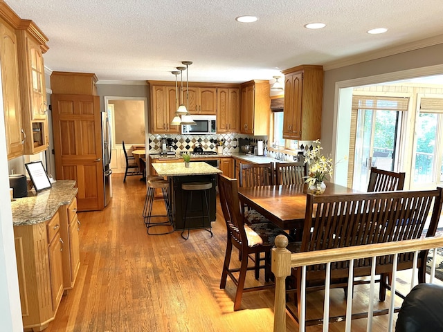 1237 Summit Oaks Dr, Burnsville, MN 55337 - dining area with crown molding, light wood-style flooring, a textured ceiling, and recessed lighting