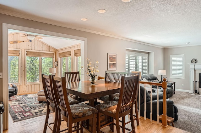 1237 Summit Oaks Dr, Burnsville, MN 55337 - dining room with crown molding, ceiling fan, a textured ceiling, a fireplace with flush hearth, and light wood finished floors