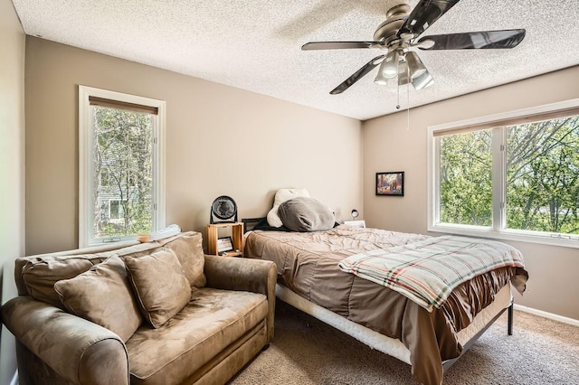 1237 Summit Oaks Dr, Burnsville, MN 55337 - bedroom featuring multiple windows, carpet flooring, a textured ceiling, and a ceiling fan