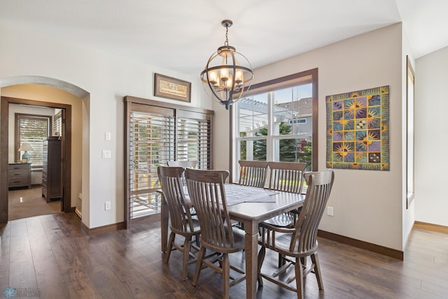 dining area with arched walkways, a chandelier, dark wood-style flooring, and healthy amount of natural light