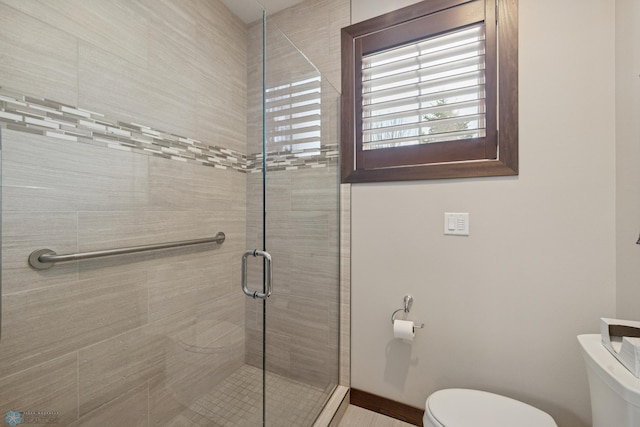 bathroom with toilet and a shower stall