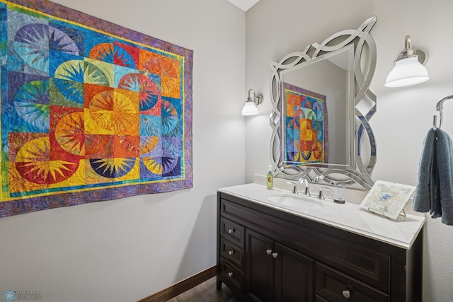 bathroom with vanity, wood finished floors, and baseboards