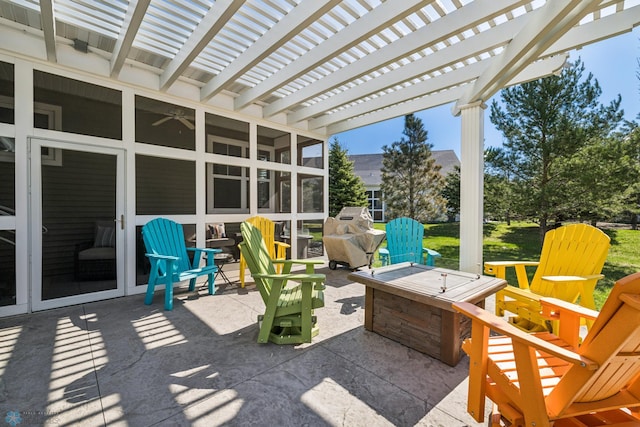 view of patio / terrace with a pergola, an outdoor fire pit, and a sunroom