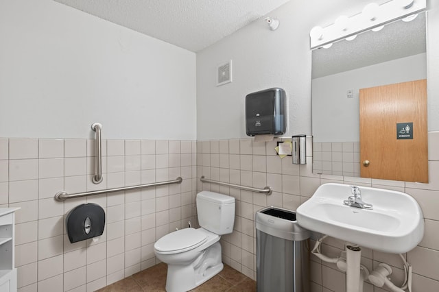 610 Whiskey Rd NW Unit 115, Isanti, MN 55040 - bathroom featuring a textured ceiling, tile walls, wainscoting, and tile patterned flooring