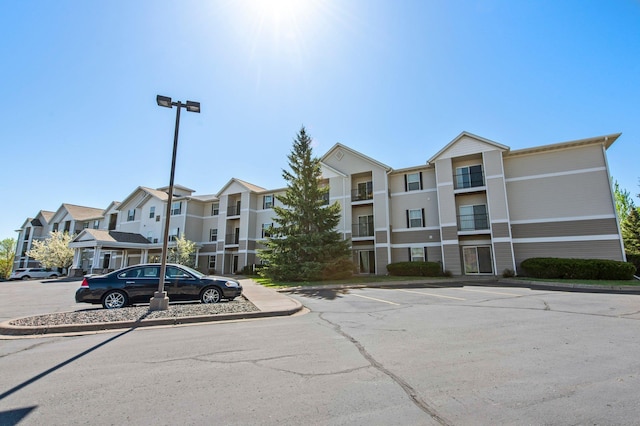 610 Whiskey Rd NW Unit 115, Isanti, MN 55040 - view of building exterior with uncovered parking and a residential view