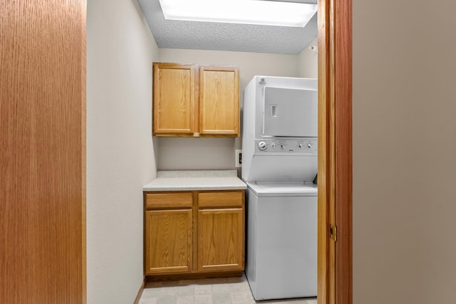 610 Whiskey Rd NW Unit 115, Isanti, MN 55040 - laundry area featuring cabinet space, stacked washer / drying machine, and a textured ceiling