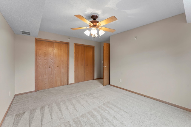 610 Whiskey Rd NW Unit 115, Isanti, MN 55040 - unfurnished bedroom with light carpet, two closets, and a ceiling fan