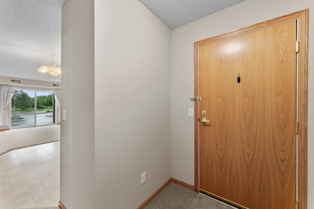 610 Whiskey Rd NW Unit 115, Isanti, MN 55040 - foyer with a textured ceiling, a chandelier, and carpet floors
