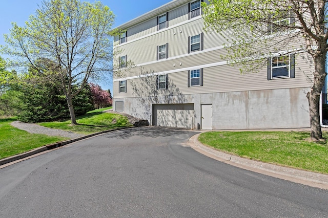 610 Whiskey Rd NW Unit 115, Isanti, MN 55040 - view of building exterior featuring driveway and a garage