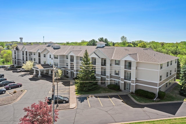 610 Whiskey Rd NW Unit 115, Isanti, MN 55040 - view of building exterior featuring uncovered parking and a residential view