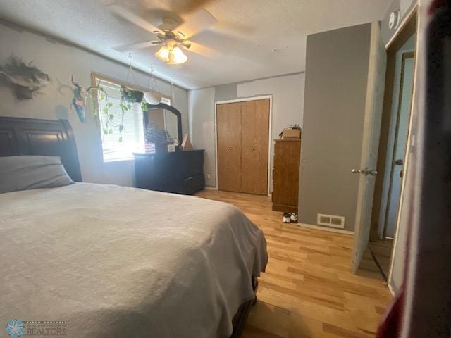 bedroom featuring light wood finished floors, a closet, and a ceiling fan