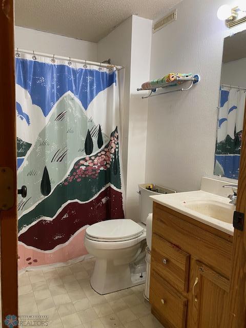 bathroom with tile patterned floors, a textured ceiling, toilet, vanity, and a shower with shower curtain
