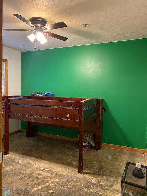 bedroom with a ceiling fan and baseboards