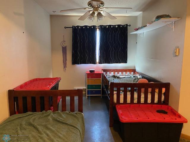 bedroom featuring concrete flooring and a ceiling fan