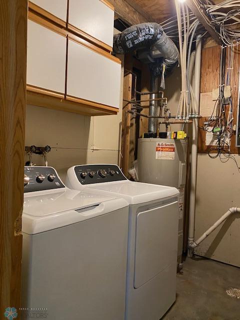 laundry room with washing machine and clothes dryer, cabinet space, and water heater