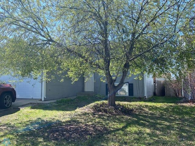 view of property exterior featuring an attached garage and a yard