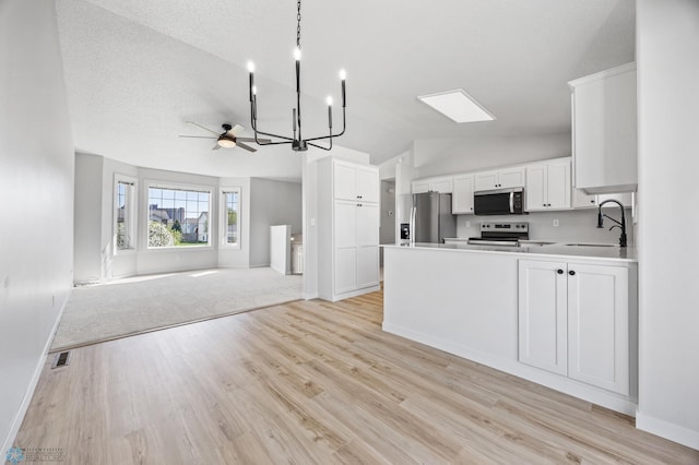 1683 Oakwood Dr, West Fargo, ND 58078 - kitchen featuring appliances with stainless steel finishes, open floor plan, vaulted ceiling, a sink, and baseboards
