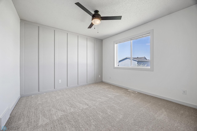 1683 Oakwood Dr, West Fargo, ND 58078 - unfurnished room featuring a ceiling fan, carpet flooring, baseboards, and a textured ceiling