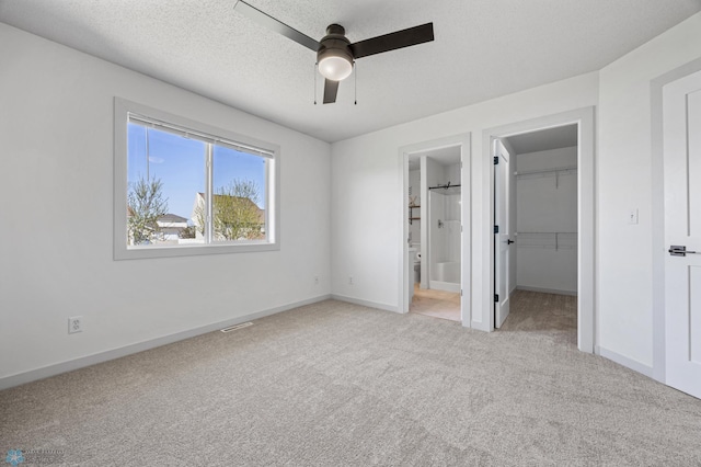 1683 Oakwood Dr, West Fargo, ND 58078 - unfurnished bedroom with light carpet, a walk in closet, connected bathroom, a closet, and baseboards