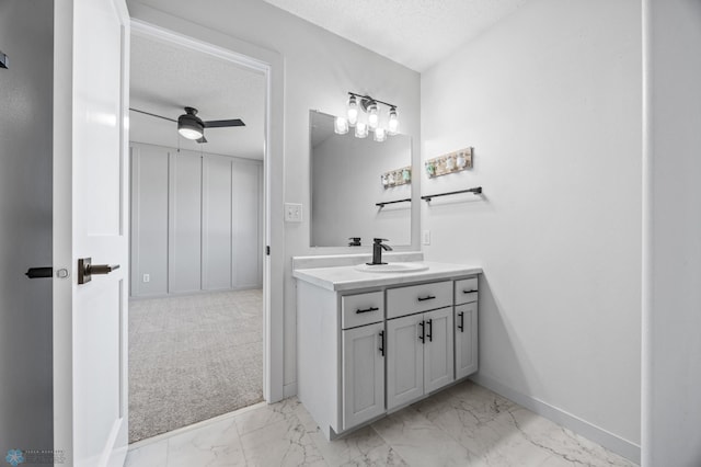 1683 Oakwood Dr, West Fargo, ND 58078 - bathroom featuring marble finish floors, baseboards, a textured ceiling, a ceiling fan, and vanity