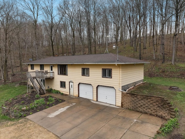 view of front facade featuring an attached garage, roof with shingles, stairway, and a wooden deck
