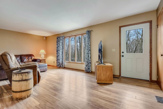 living area with light wood finished floors, a wealth of natural light, and visible vents