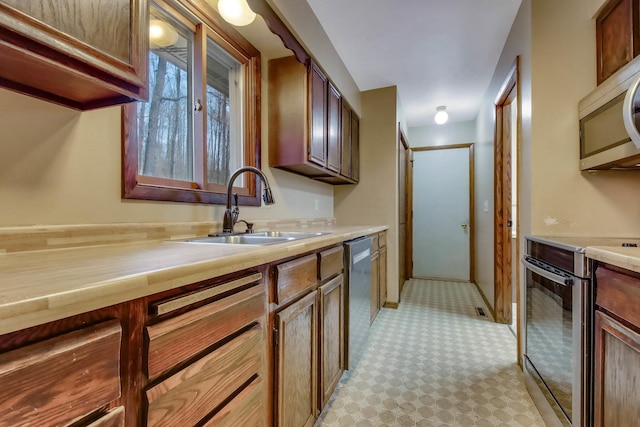 kitchen featuring light countertops, stainless steel appliances, and a sink