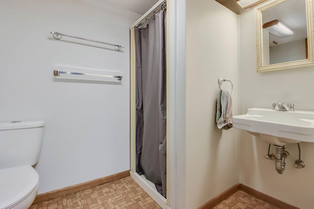 full bathroom featuring curtained shower, toilet, and baseboards