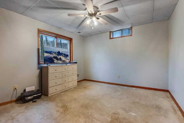 unfurnished bedroom featuring concrete flooring, baseboards, and a ceiling fan