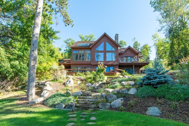 rear view of house featuring a wooden deck and a chimney